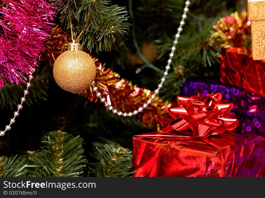 Christmas tree with gold ornament ball, close up