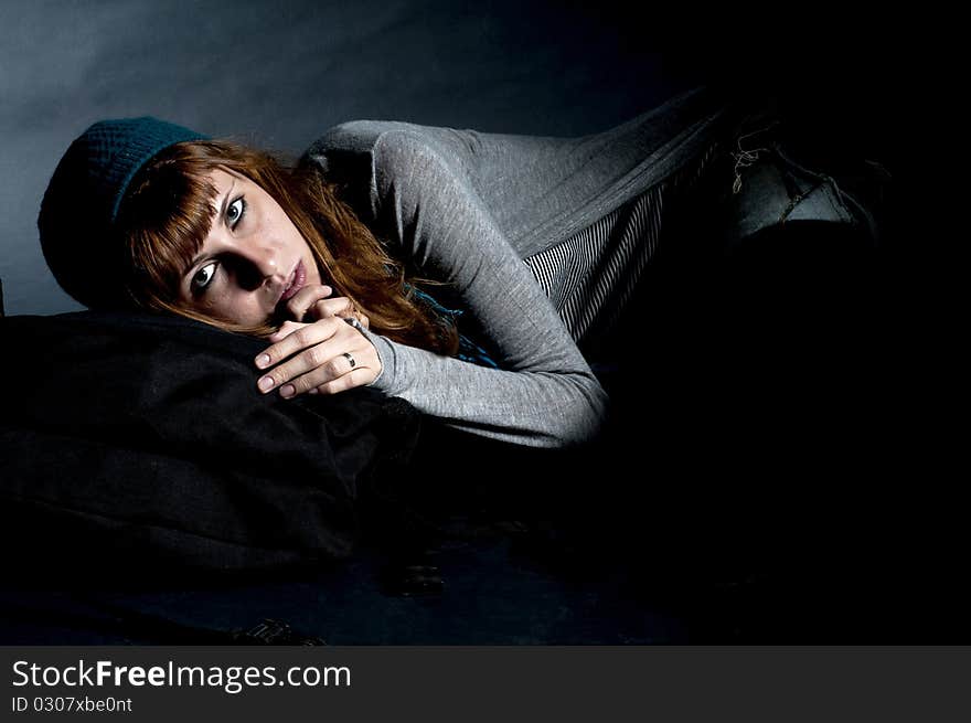 Beautiful girl with scarf, hat and bag on a black background