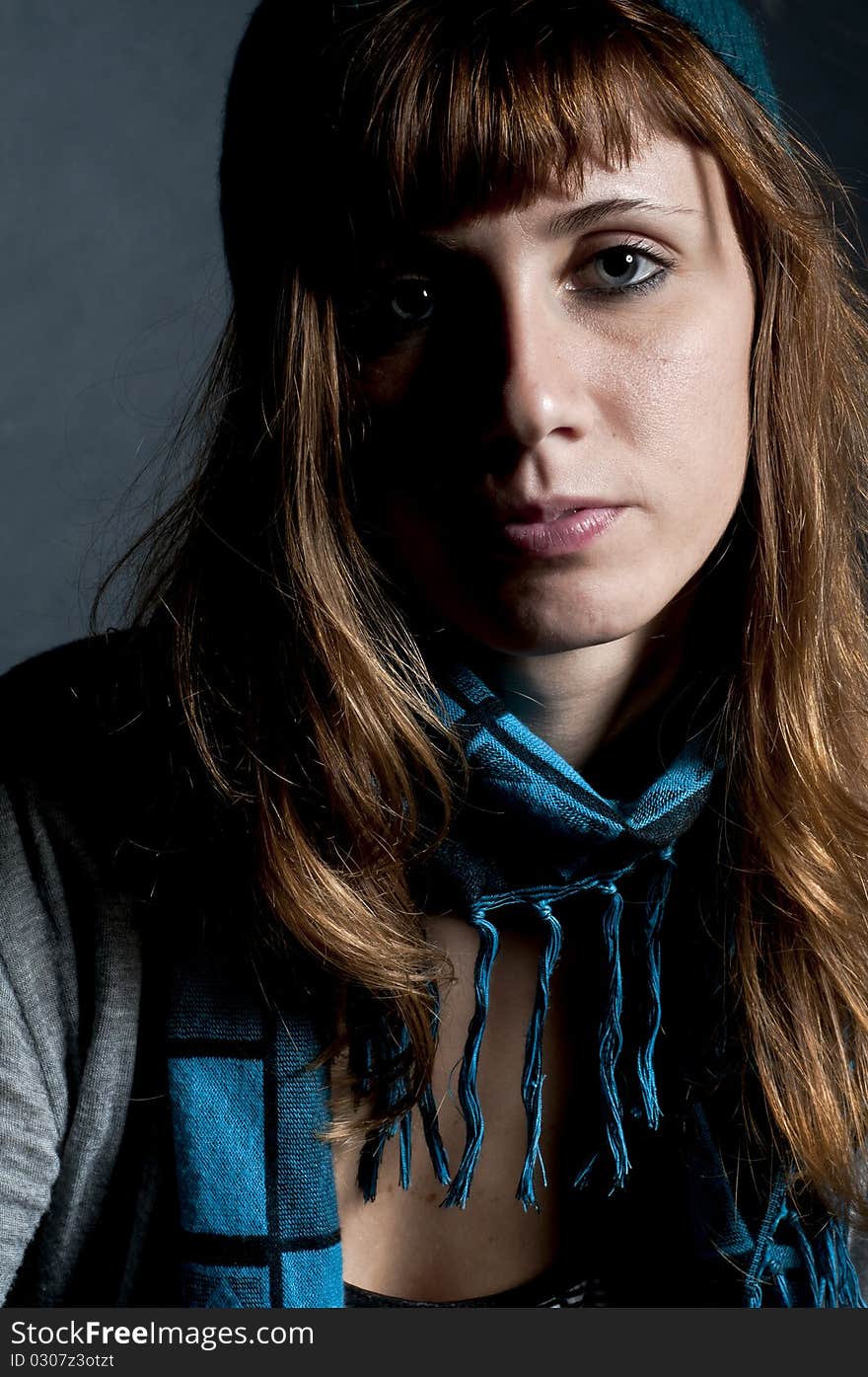 Beautiful girl with scarf, hat and bag on a black background