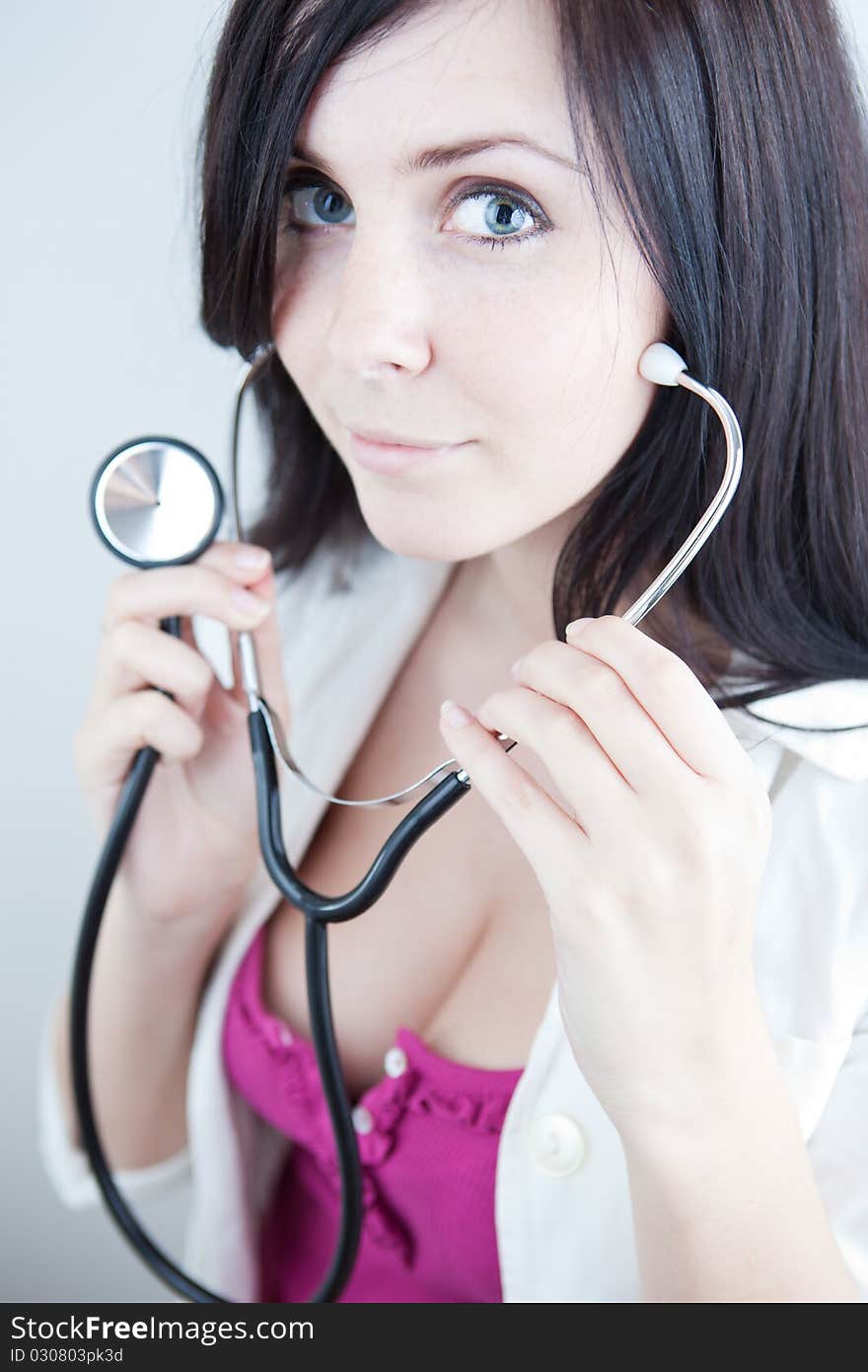 Very pretty young doctor with stethoscope (shallow DOF, selective focus; color toned image)