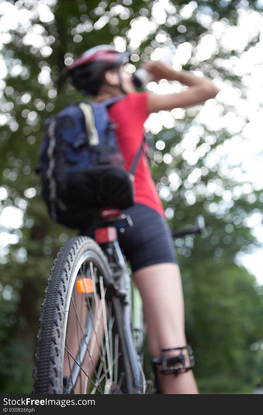 Pretty young female biker outddors on her mountain bike (shallow DOF; selective focus). Pretty young female biker outddors on her mountain bike (shallow DOF; selective focus)