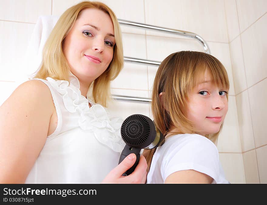 A young girl and her mother take care of the hair in his bathroom