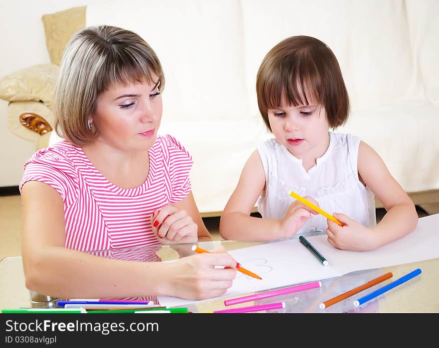 Mother and daughter together paint an album and have fun together.