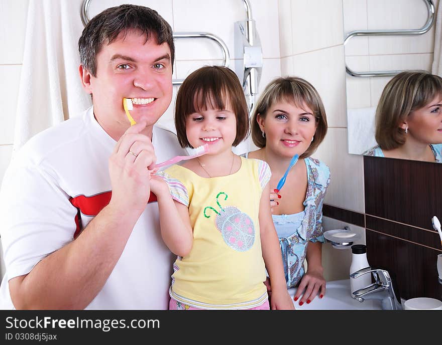 Mom, Daughter And Father Brush Their Teeth