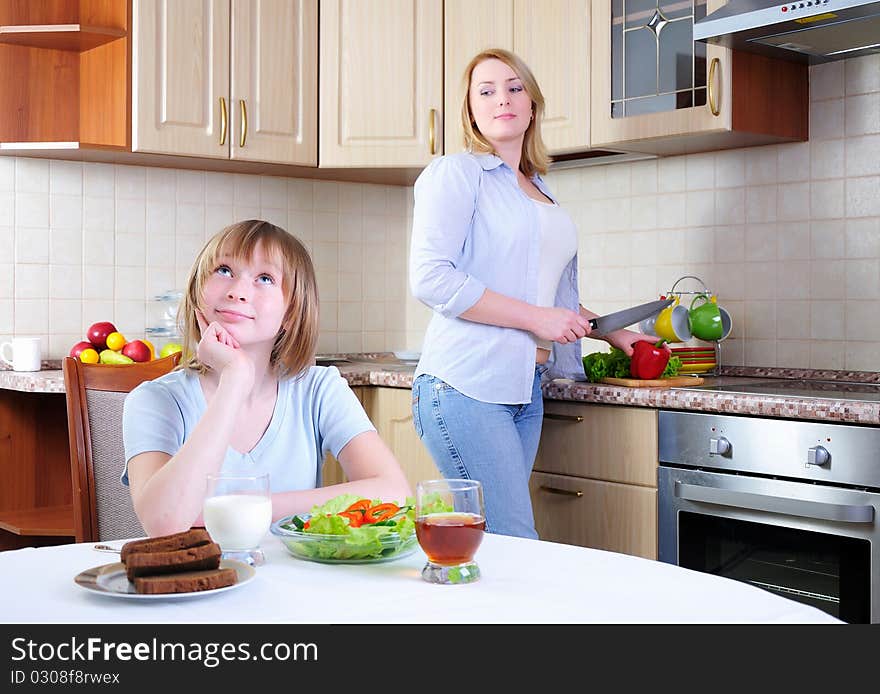 Mom and young daughter eating breakfast together in the kitchen