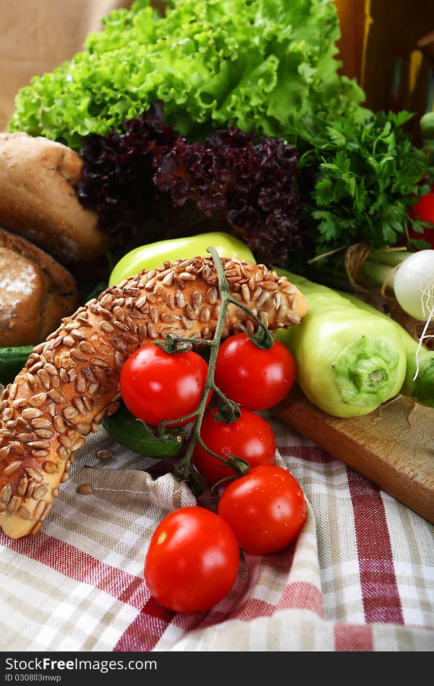 Vegetables and the bottle of olive oil placed on a kitchen table. Vegetables and the bottle of olive oil placed on a kitchen table