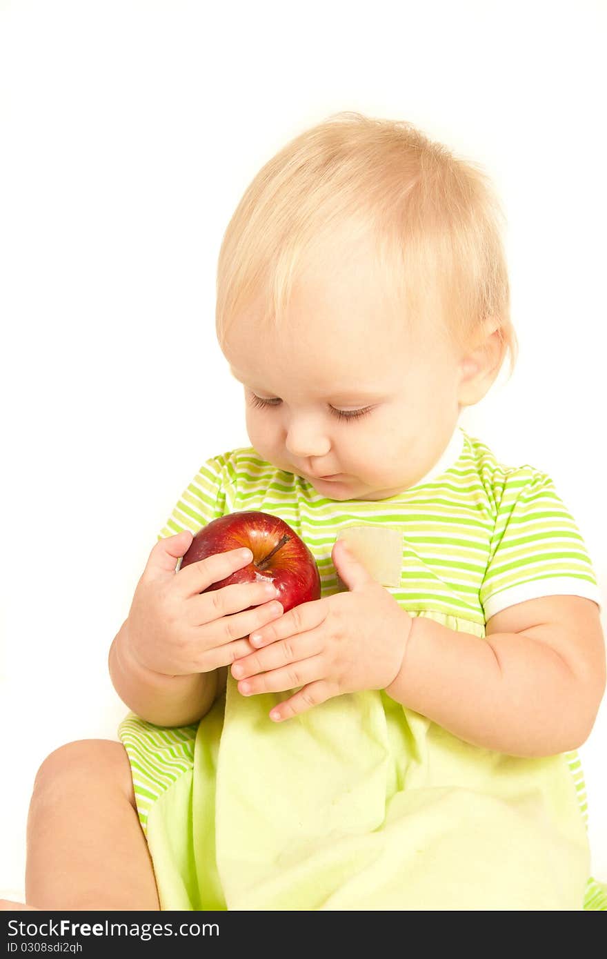 Young little baby eat red apple on white