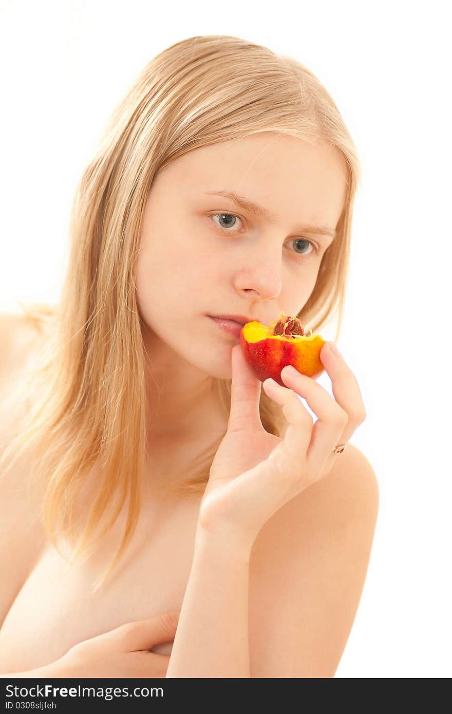 Beautiful young girl eating a peach on white.