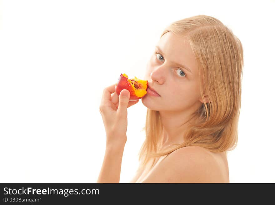 Beautiful young girl eating a peach on white. Beautiful young girl eating a peach on white