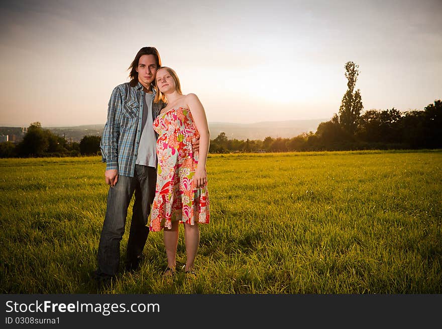 Lovely couple flirt in field on sunset