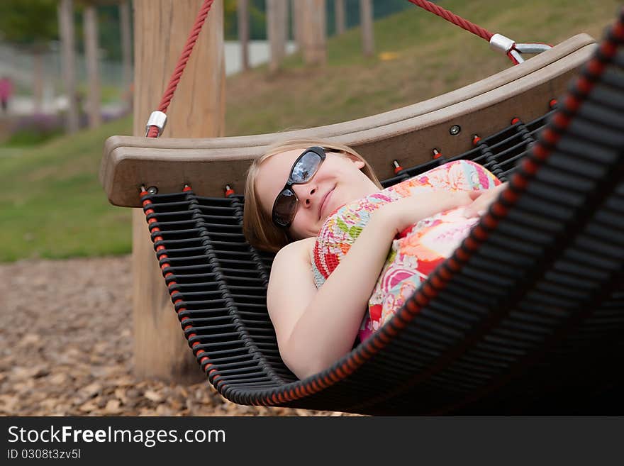 Beautiful woman relaxing in hammock in park