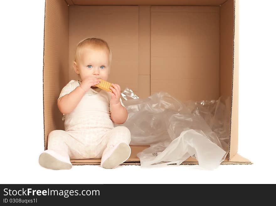 Cheerful young baby sit in paper box and eat cookie on white background