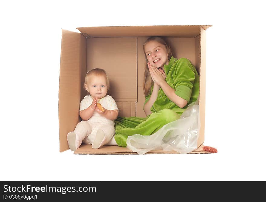 Cheerful mother sit in box with baby eating cookie. Cheerful mother sit in box with baby eating cookie