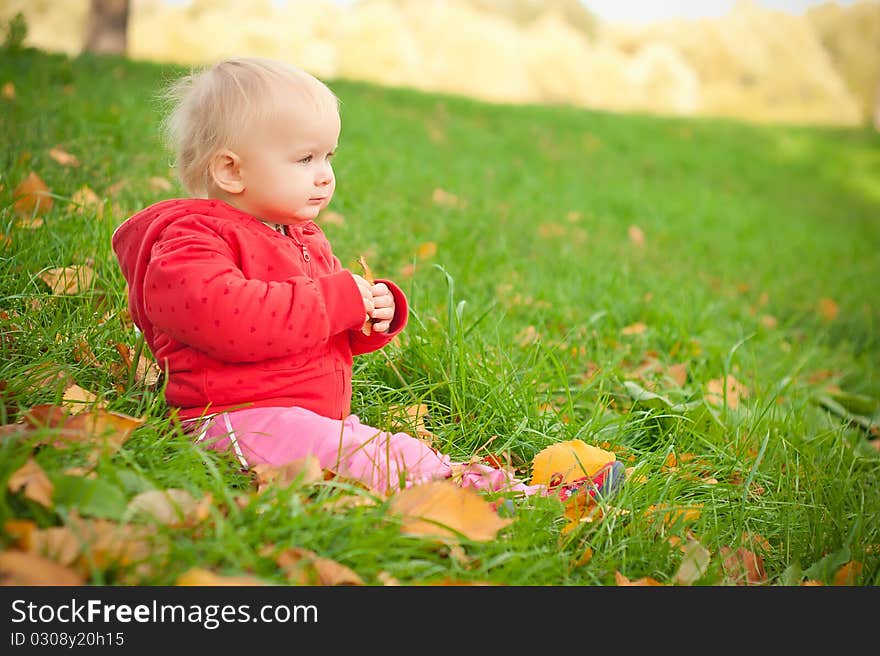 Adorable Baby Sit On Green Grass In Hill