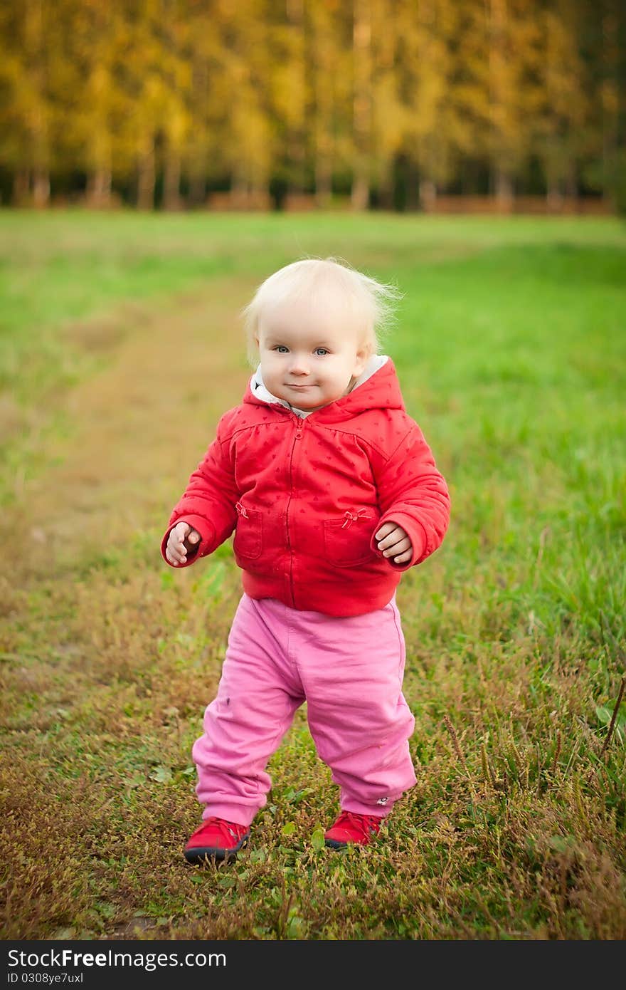 Cheerful baby walk on grass road in park