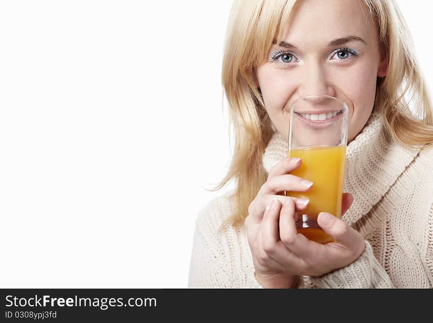 A woman in a sweater drinking juice on a white background. A woman in a sweater drinking juice on a white background