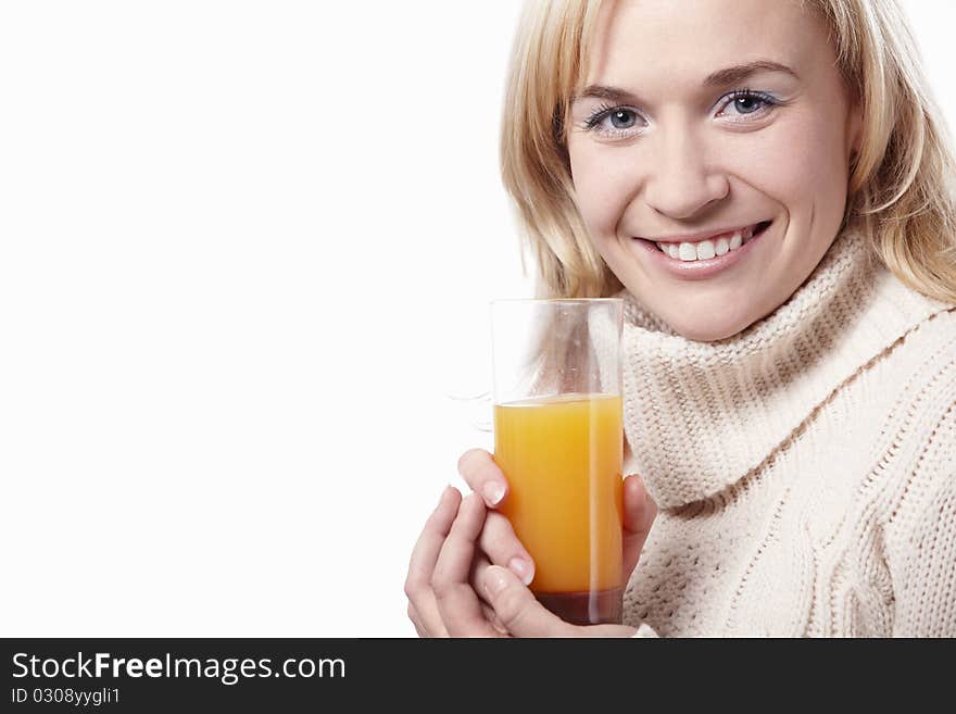 A woman in a sweater with a glass of juice on a white background. A woman in a sweater with a glass of juice on a white background