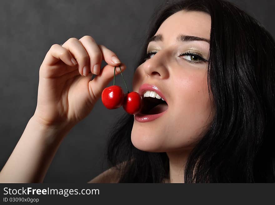 A beautiful girl eats a cherry. A beautiful girl eats a cherry