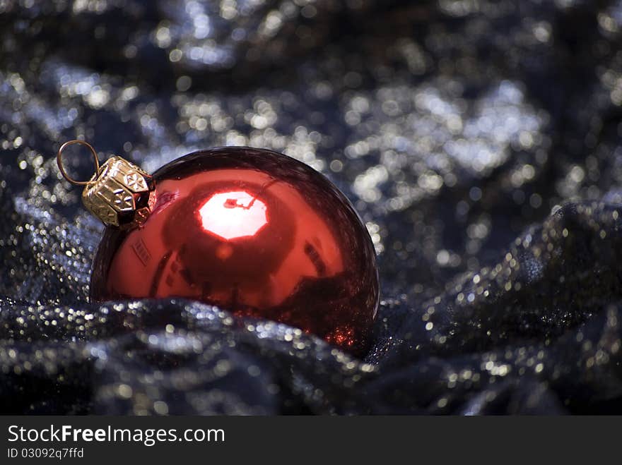 Red Christmas ball on the sheer black material. Red Christmas ball on the sheer black material