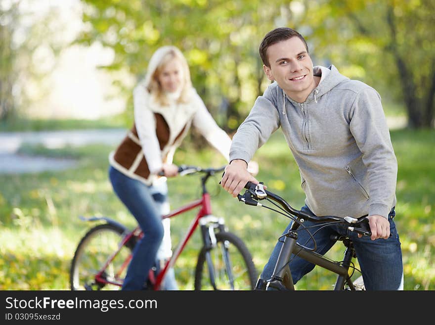 A man on a bicycle in the park in the foreground. A man on a bicycle in the park in the foreground