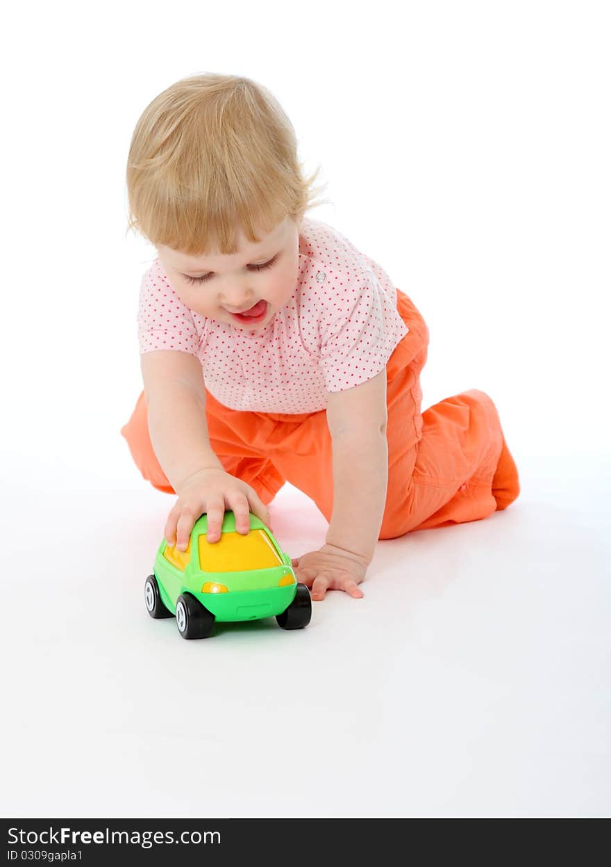 Studio portrait of 1 year old baby playing with a toy car on white background