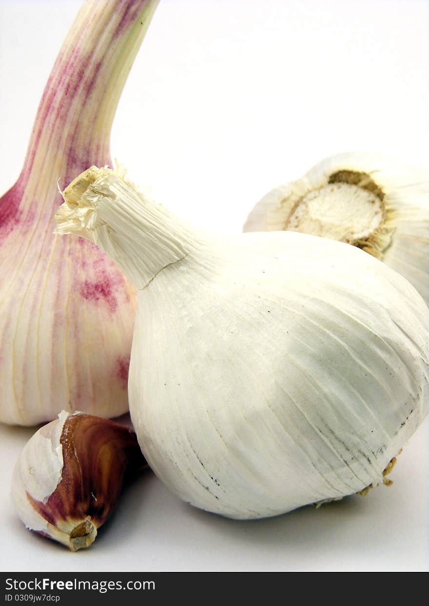 A selection of different pieces of garlic on a white background. A selection of different pieces of garlic on a white background