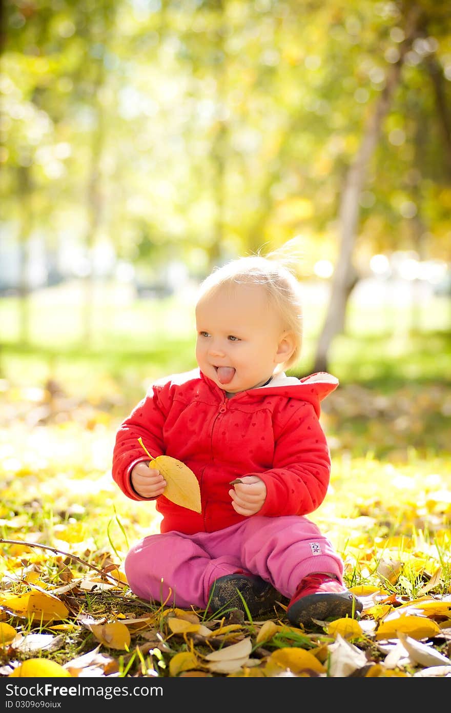 Cheerful baby play with yellow leafs