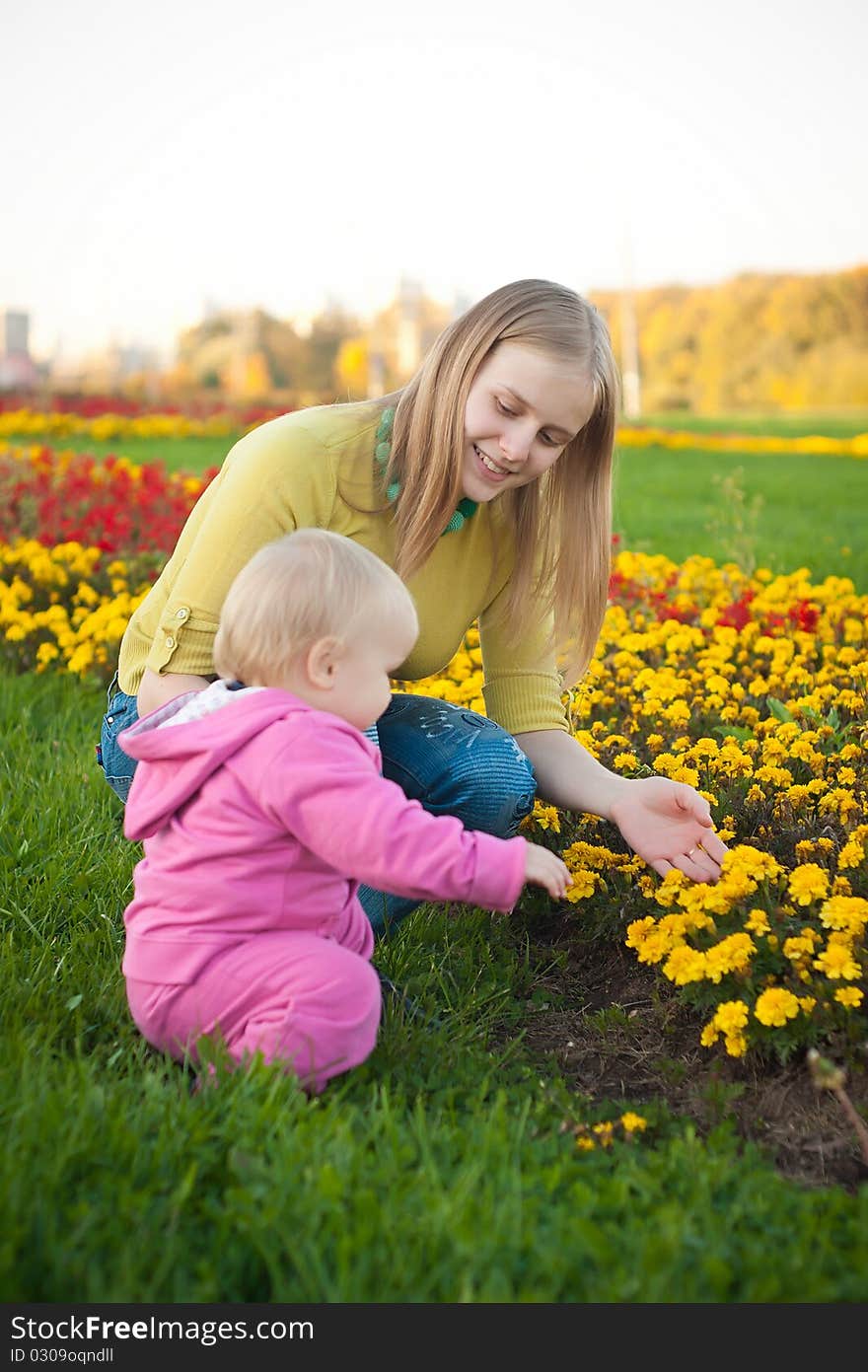 Young woman show flowers  to baby