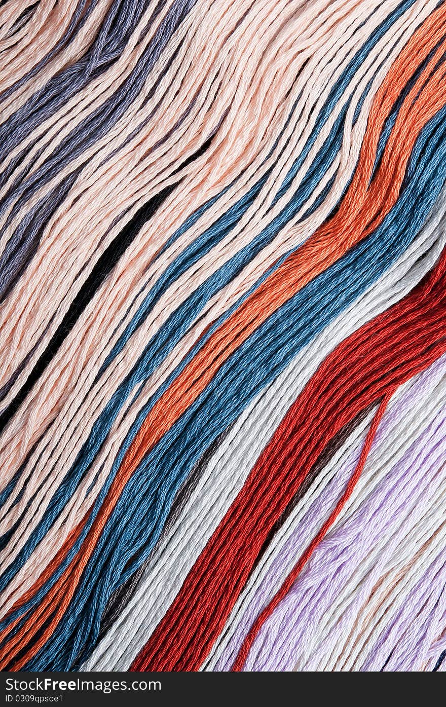 Close-up of multicolored embroidery threads backgrounds, vertical