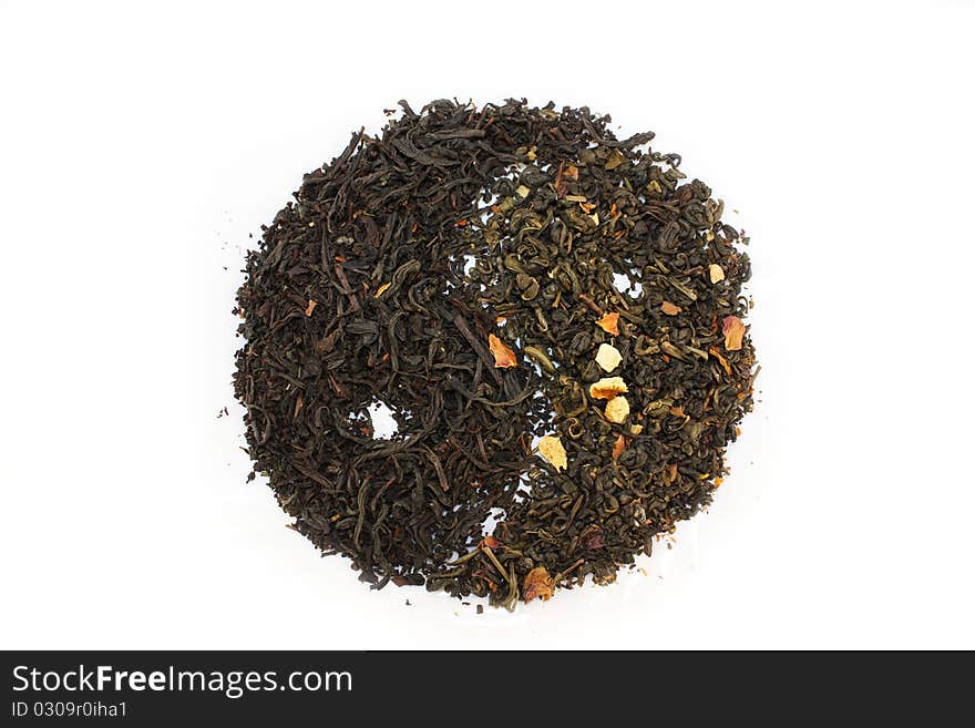 Sprinkle of green and black tea on a white background in the shape of the yin-yang