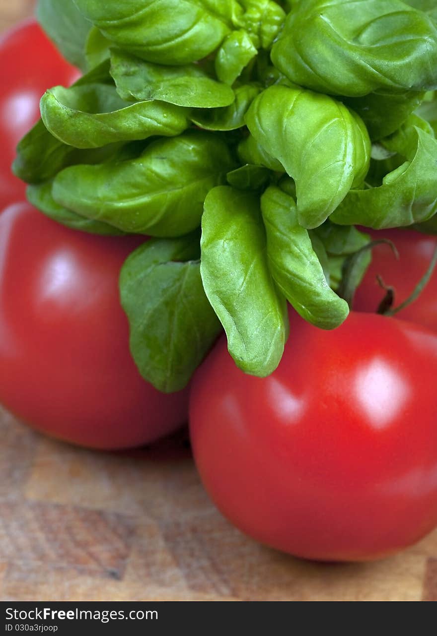 Basil and tomatoes on a wooden board. Basil and tomatoes on a wooden board