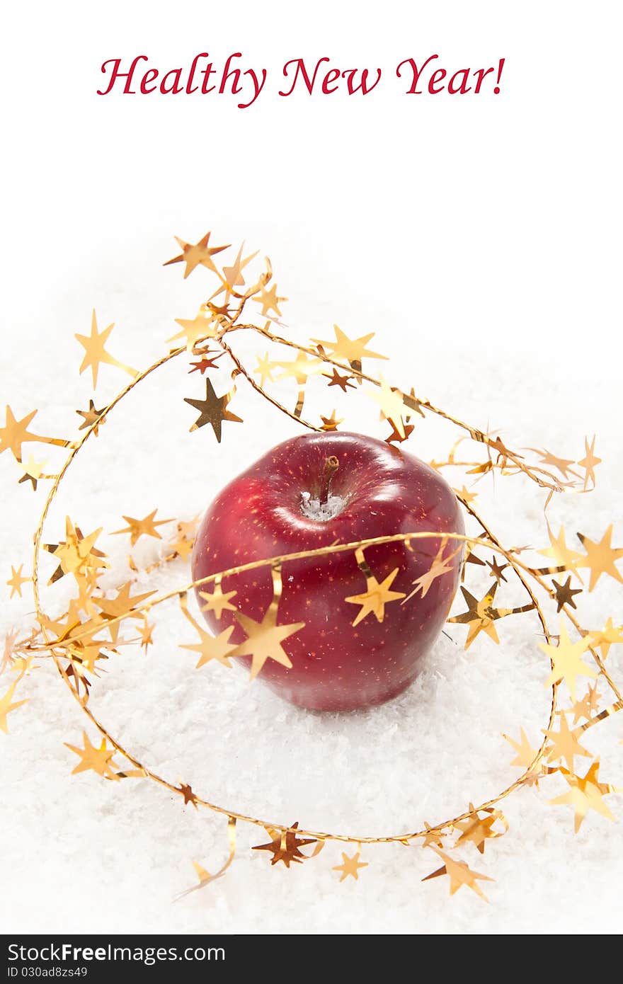 Fresh red apple with christmas stars on the white snow