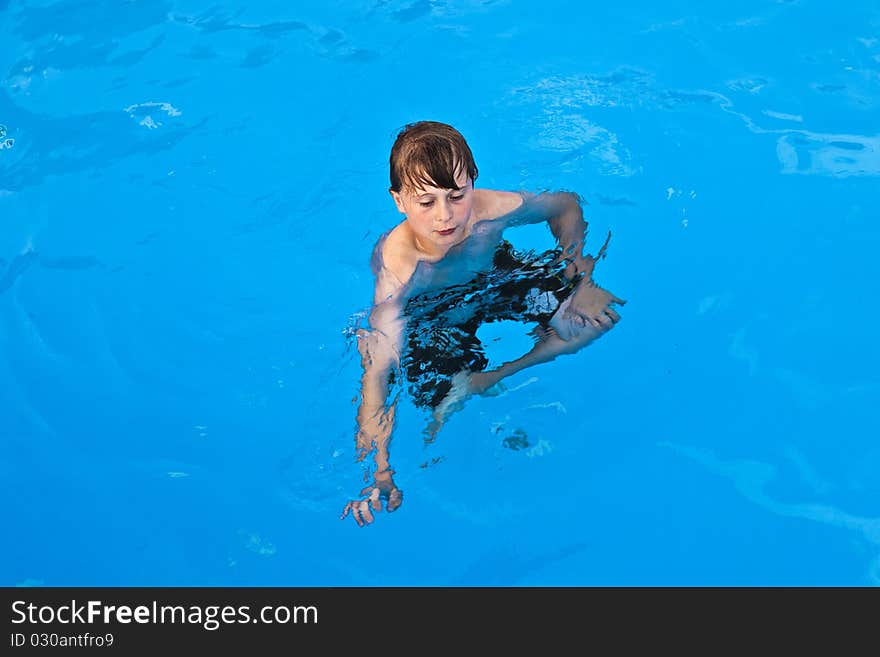 Boy has fun swimming in the pool