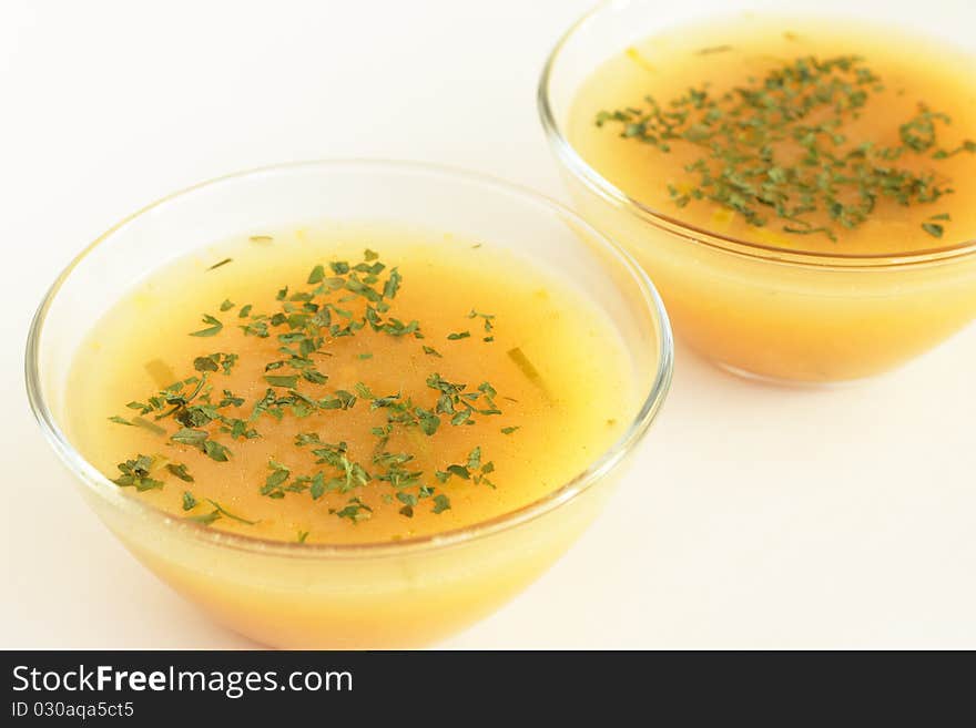 Two bowls of hot pumpkin soup on white background