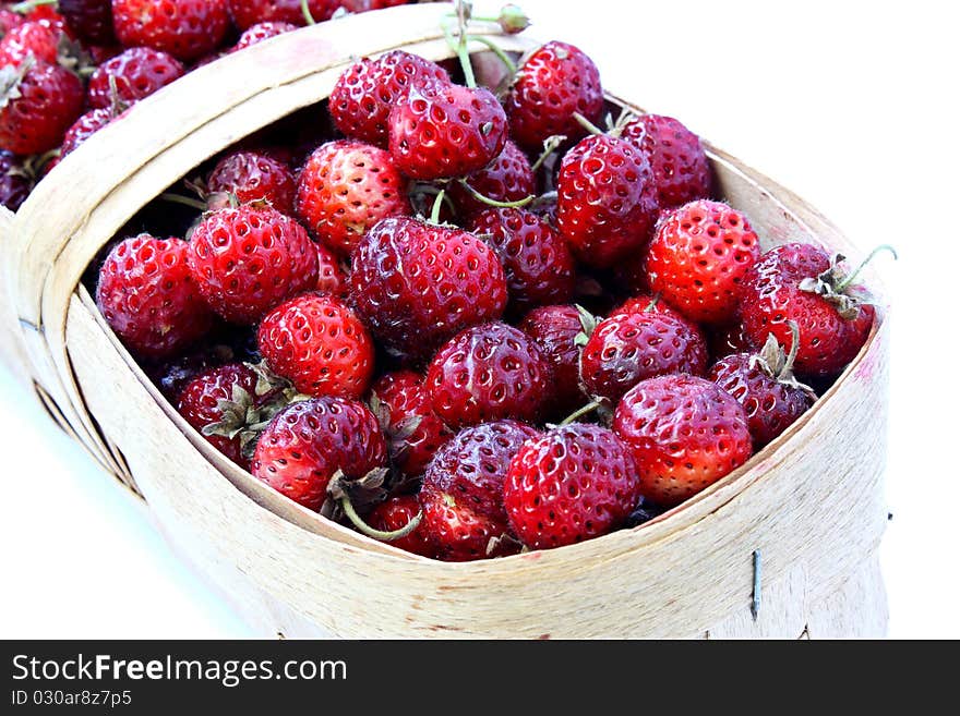 Wild strawberry in a basket on a white background