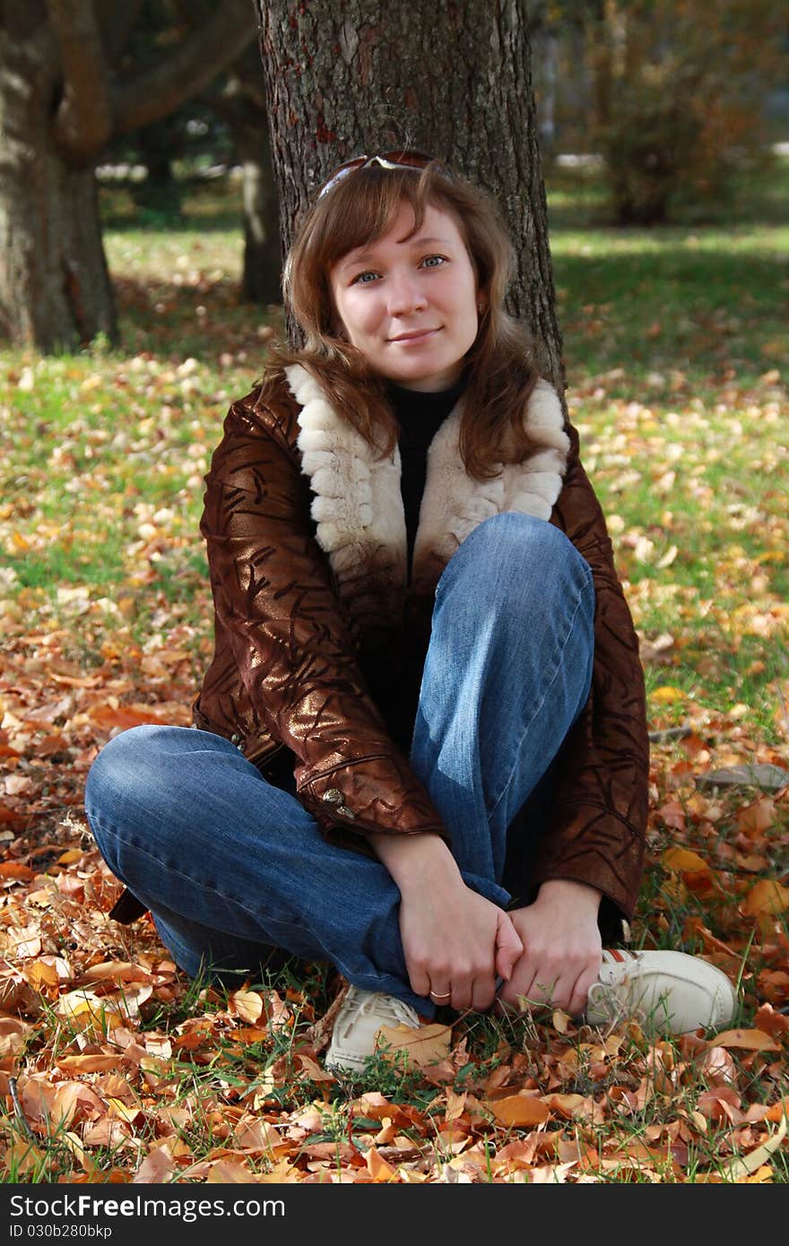 Girl sits in autumn park