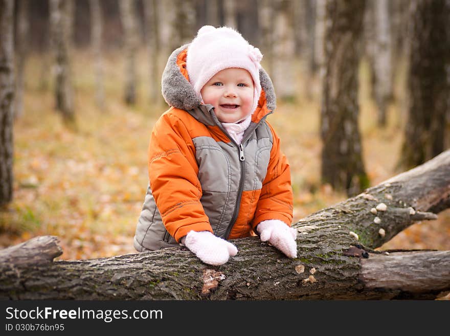 Cute adorable baby smile and stay near fallen tree. Cute adorable baby smile and stay near fallen tree