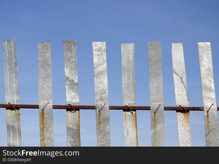 Metallik fence on blue sky background