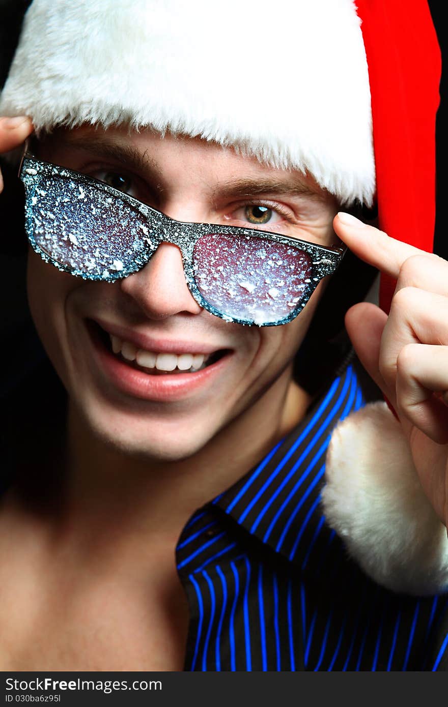 Portrait of a handsome young man in Santa Claus hat. Christmas. Portrait of a handsome young man in Santa Claus hat. Christmas.