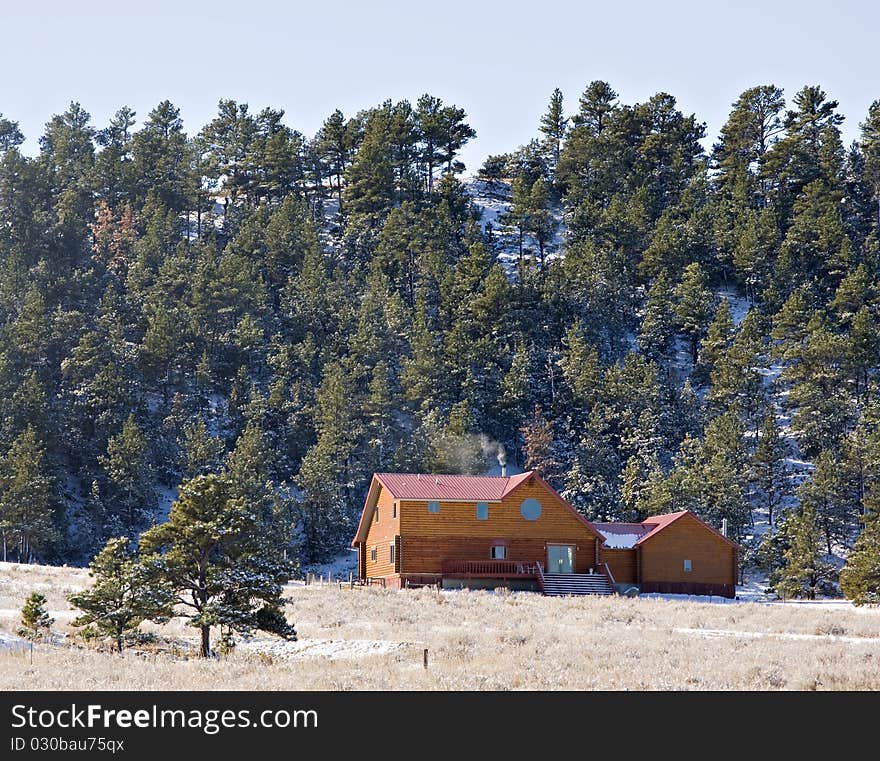 Wood cabin in the hills in the winter with snow on the ground