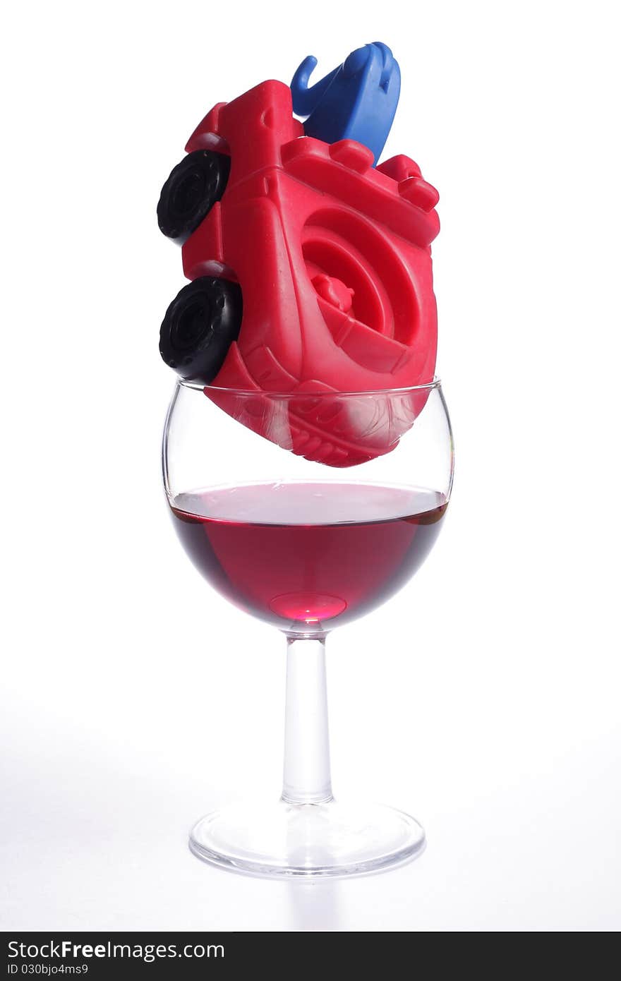 Toy truck placed inside a glass of red wine. Toy truck placed inside a glass of red wine