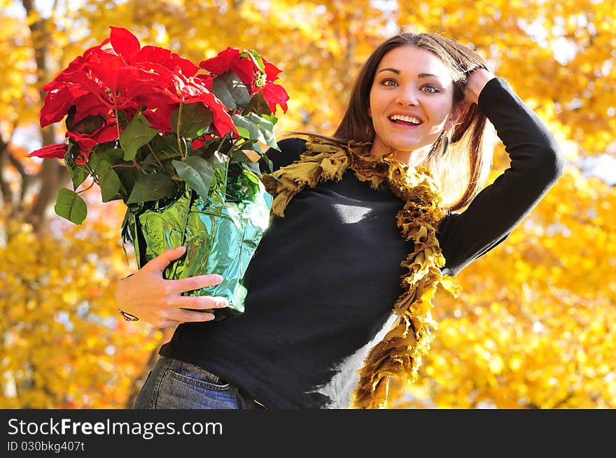 Happy girl holding a poinsettia flower arrangement. Happy girl holding a poinsettia flower arrangement