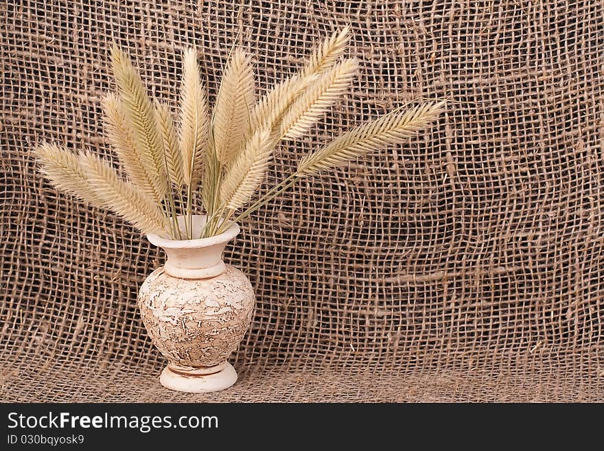 Jug with ears background  of rough material