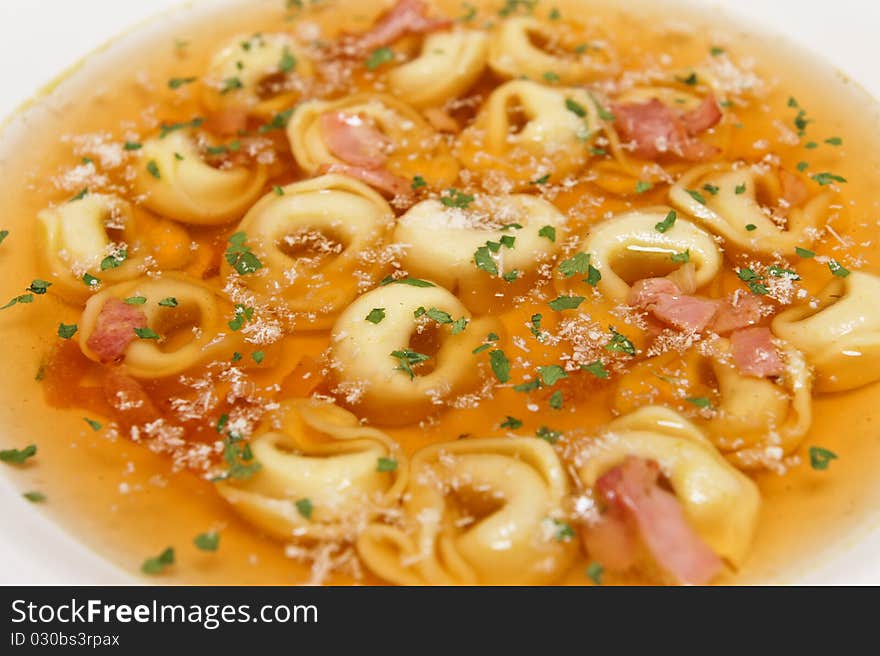 Food styling of Tortellini soup with ham and herbs