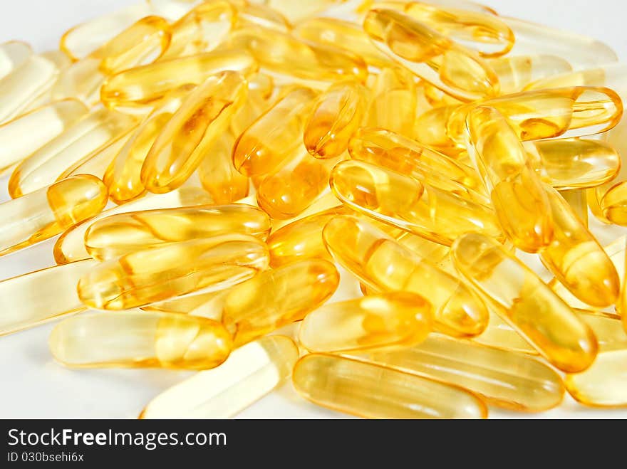 Pile of shiny yellow capsule vitamin background