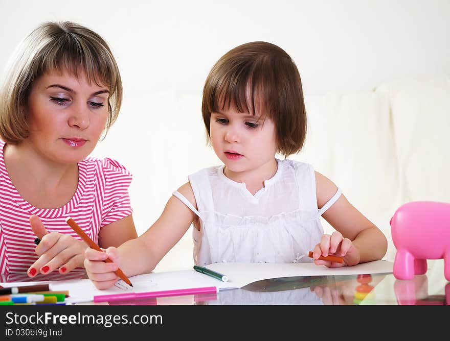 Mother and daughter together paint an album and have fun together.