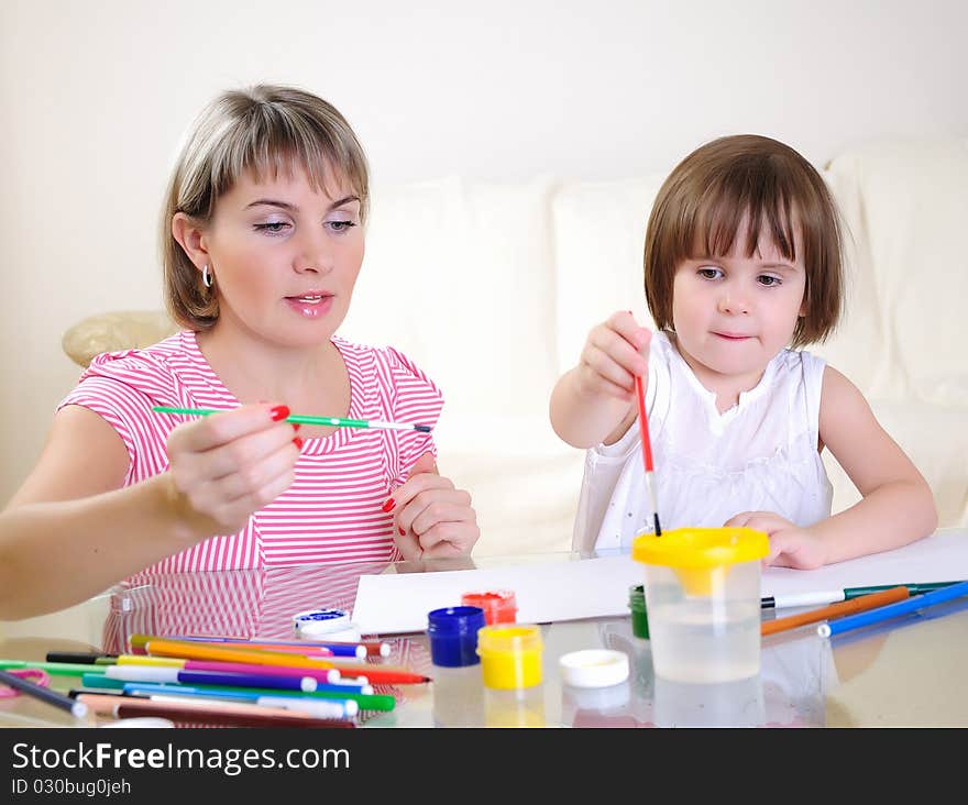 Mother and daughter together paint an album and have fun together.