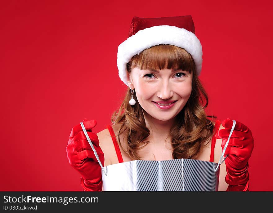 A young girl dressed as Santa Claus on a red background