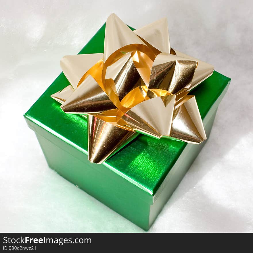 Metallic green gift box with gold metallic bow on top. Metallic green gift box with gold metallic bow on top