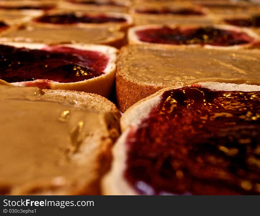 Seemingly endless supply of peanut butter and jelly sandwiches being assembled. Seemingly endless supply of peanut butter and jelly sandwiches being assembled.